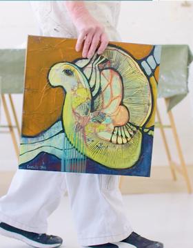 Henriette Lorentz bærer et af sine malerier mellem hendes skulturer